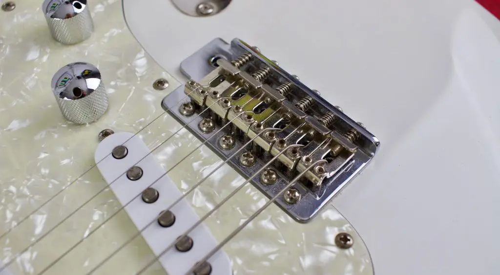Nel nostro esempio usiamo una Stratocaster con tremolo vintage. Prima di regolare il ponte per l'intonazione e l’azione delle corde, è necessario effettuare la regolazione desiderata della leva del tremolo