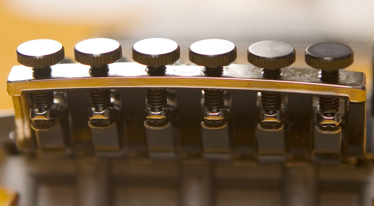 Attenzione: prima di infilare le corde nelle meccaniche, è necessario spostare gli accordatori del sistema tremolo in posizione centrale. In questo modo si garantisce una portata di regolazione sufficiente in entrambe le direzioni dopo il bloccaggio del capotasto.