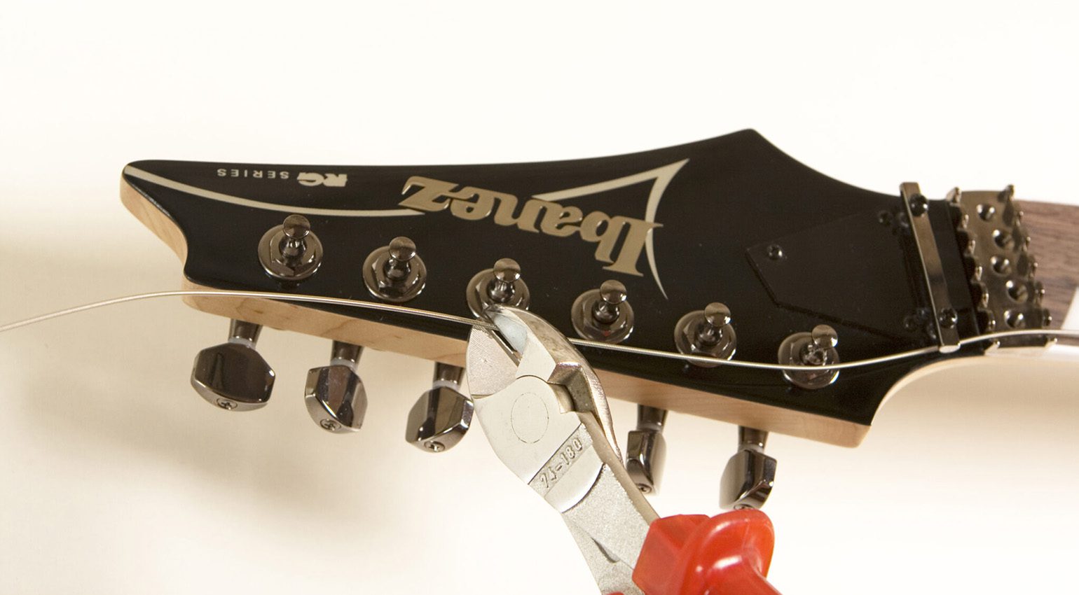 Per limitare il numero di avvolgimenti, tagliare le estremità delle corde a una lunghezza che corrisponda a tre meccaniche (ad esempio, tagliare l'estremità della corda di Mi all'altezza dell'accordatura di Sol e così via).